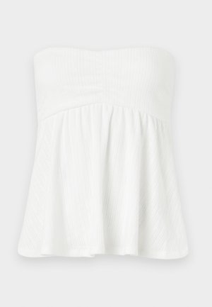 Top blanco sin tirantes con un diseño fruncido y acampanado. Presenta rayas verticales texturizadas y un corpiño ajustado con elástico en la parte superior.