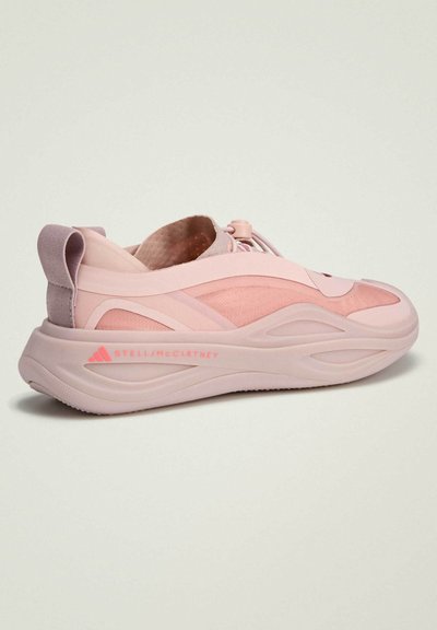 Light pink sneaker with a textured mesh upper, seamless construction, and a cushioned sole. Features logo in pink on the side.