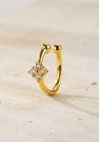 Goldring mit doppeltem Band, das ein sternförmiges Design mit vier klaren Steinen zeigt, polierte Oberfläche und abgerundete Enden.