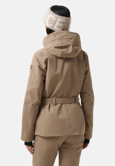 Braune Skijacke mit Kapuze, tailliertem Schnitt und strukturierter Stoffqualität. Verfügt über dezente Markenkennzeichnung und eng anliegende Bündchen mit glatter Oberfläche.