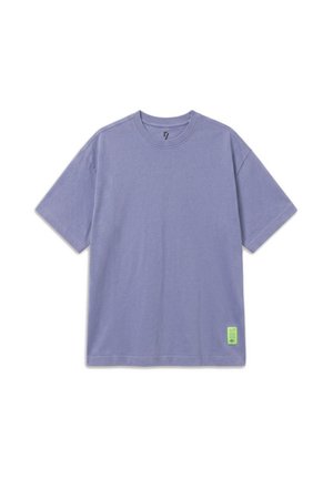 Prosty jasnofioletowy T-shirt z krótkim rękawem, okrągłym dekoltem i małą zieloną metką przy szwie na białym tle.