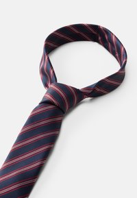 Tumed lips punane ja valge diagonaalsete triipudega, tekstureeritud kangas, terava otsaga ja sõlme osaga ülaosas.