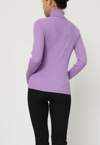 Pull à col roulé côtelé vert menthe avec manches longues ; design ajusté ; vue arrière montrant un col haut et un ourlet droit.