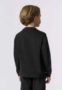 Felpa nera realizzata in un tessuto morbido, con scollo rotondo, maniche lunghe e polsini a costine. Il design è semplice e non presenta loghi visibili.