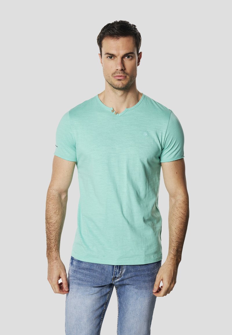 Mintgrünes T-Shirt mit kurzen Ärmeln und Rundhalsausschnitt aus leichtem Stoff. Verfügt über ein kleines Logo auf der Brust und dezente Nähte.