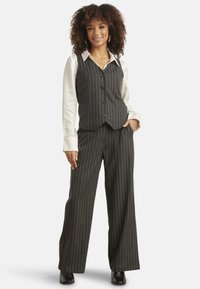 Pinstripe vest and wide-leg pants set in dark gray, featuring a white collared shirt underneath. Smooth fabric texture, button details prominent.
