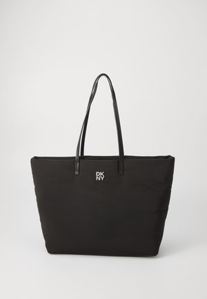 Zwarte draagtas gemaakt van zacht materiaal, met twee lange zwarte handvatten en een zilveren DKNY-logo aan de voorkant. Eenvoudig, rechthoekig ontwerp.