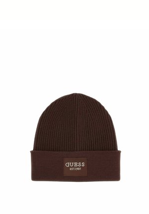 Brązowa dziana czapka z wywiniętym mankietem i naszywką z napisem "GUESS EST. 1981" na środku z przodu.