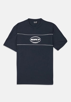 T-shirt en coton bleu marine à manches courtes, avec un logo blanc et des rayures sur la poitrine. Encolure ras du cou, coupe décontractée.