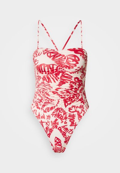 Maillot de bain une pièce présentant une base crème avec des motifs de texte abstrait rouges, un détail froncé au niveau du buste et des bretelles spaghetti réglables.