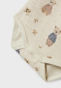 Beige babybodysuit med tryckknappar, med små mönster av nallar och blad i mjuka bruna och blå nyanser.