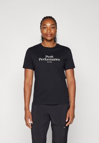 Czarny bawełniany T-shirt z krótkim rękawem, z białym napisem "Peak Performance Est. 1986" umieszczonym na środku klatki piersiowej. Prosty krój z okrągłym dekoltem.