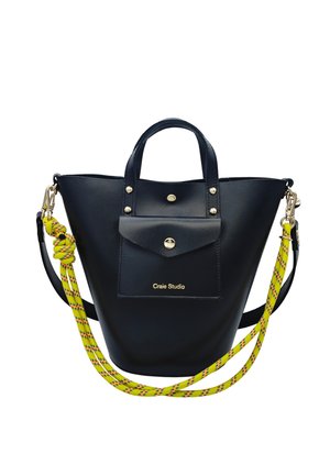 Sac seau en cuir noir avec poche avant, fermetures boutons dorés et bandoulière amovible en corde jaune avec détails noirs et rouges.
