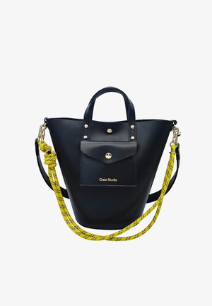 Sac seau en cuir noir avec poche avant, fermetures boutons dorés et bandoulière amovible en corde jaune avec détails noirs et rouges.