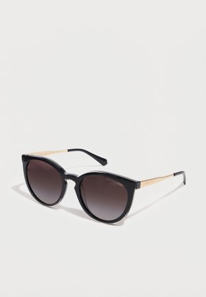 Black cat-eye sunglasses with gradient dark lenses and slender gold arms on a white background.