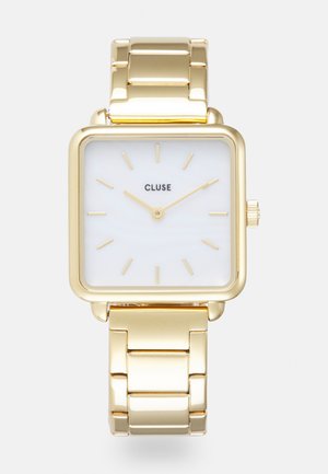 Gold rectangular watch with a white dial, minimalistic gold hour markers, and a polished gold metal bracelet. Features crown for adjustments.