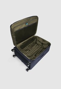 Marineblauwe koffer met een getextureerde buitenkant, geopend om een groene binnenkant te onthullen met een gaasritszakje en verstelbare banden voor organisatie.