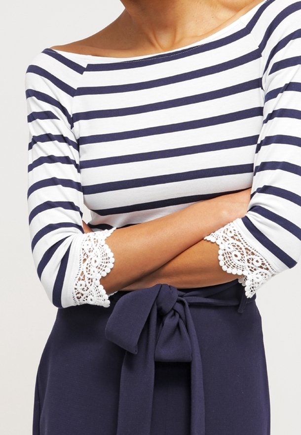 Navy and white striped top with three-quarter sleeves featuring lace trim at the cuffs, paired with a fitted navy waist tie.