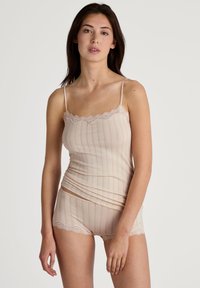 Beige camisole with adjustable spaghetti straps, featuring a lace trim and vertical stripes. Paired with matching shorts, also with lace edges.