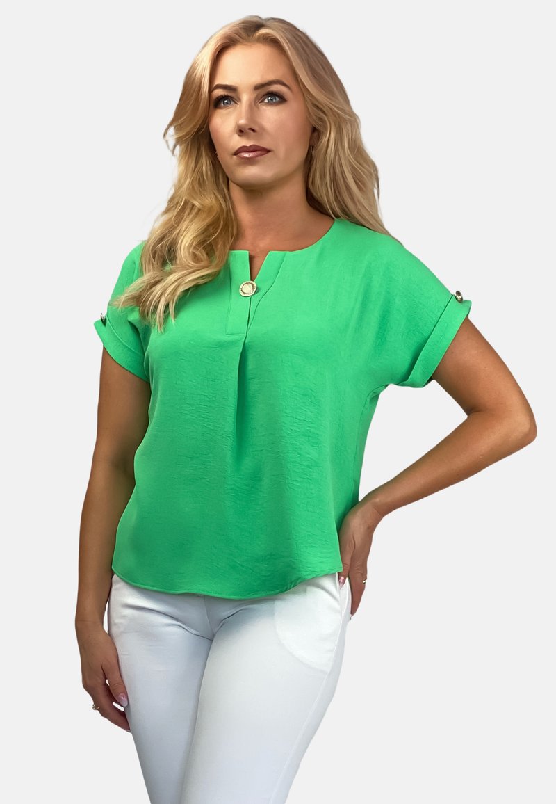 Zielona bluzka z krótkim rękawem wykonana z lekkiego materiału, z okrągłym dekoltem, ozdobnym guzikiem i podwiniętymi rękawami.
