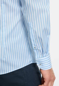 Hellblau gestreiftes Hemd mit weißen Streifen, mit Manschettenknöpfen, weicher Stoffstruktur, slim fit Design und klassischem Kragen.