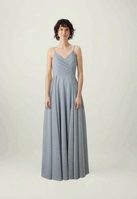 Garšīga, plūstoša kleita no maiga zila auduma ar smalku spīdumu. Tam ir plānas siksnas un pieguļoša augšdaļa ar krītošu dizainu.