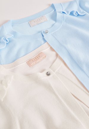 Dwa kardigany: jeden jasnoniebieski z falbankowymi akcentami i błyszczącym guzikiem oraz jeden kremowy o gładkiej fakturze i podobnym wzorze guzika.