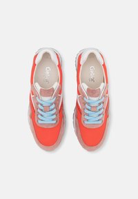 Baskets de sport orange vif avec des lacets bleu clair, en matériaux suédé et mesh, accents blancs et design de semelle rembourrée.