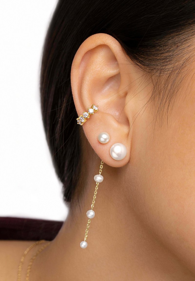 Pendientes de oro con un diseño de racimo que presenta piedras preciosas transparentes y perlas colgantes de diferentes tamaños, mostrando texturas suaves y formas elegantes.