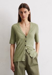 Hellgrüner Rippstrickcardigan mit kurzen Ärmeln, tiefem V-Ausschnitt, Knöpfen vorne und subtiler Textur, kombiniert mit passenden lockeren Hosen.
