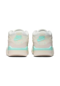 Sneakers Nike Air z białą cholewką o przezroczystym wzornictwie, miętowymi akcentami, wyściółką w kołnierzu oraz wyraźnym logo na pięcie.