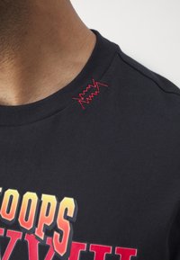 Zwarte sweatshirt met meerkleurige grafische tekst en rode geborduurde details op de schouder. Zacht katoenen stof met een ronde hals ontwerp.