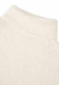 Baltas megztinis su iškilniu aukštu apykakle, pasižymintis švelnia tekstūra ir švelniais siūlų atspalvių skirtumais, rodančiais šilumą ir komfortą.