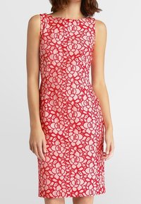 Rotes Spitzenkleid mit blumenmuster, ärmellosem Design, figurbetontem Schnitt und knielangem Saum. Die Textur zeigt erhabene Blumenmuster in Weiß.