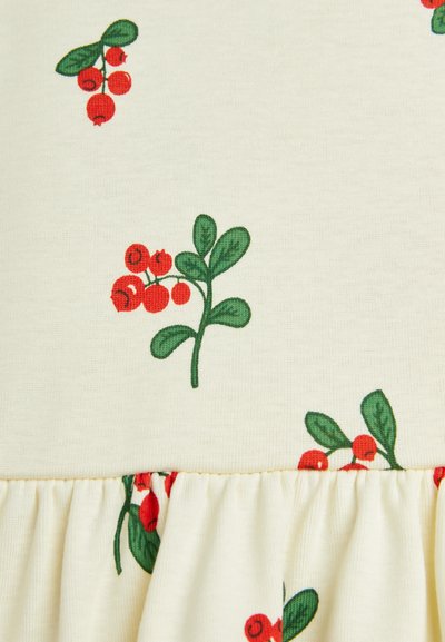 Light yellow fabric featuring red berry and green leaf patterns. Detail includes a gathered ruffle at the bottom. Smooth texture overall.