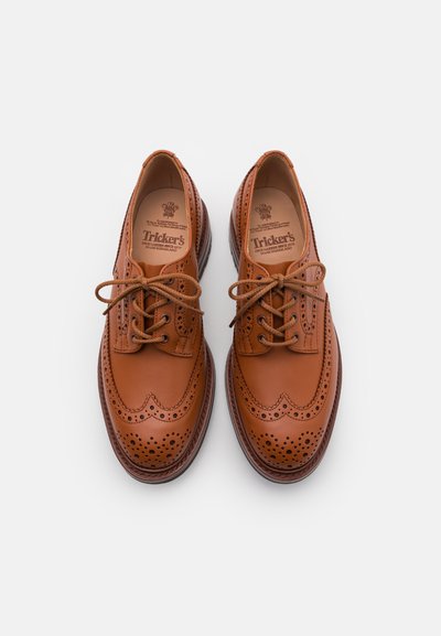 Zapatos brogue de cuero marrón con detalles perforados, punta redondeada y cordones. Cuenta con una suela estratificada y una marca interior en relieve.