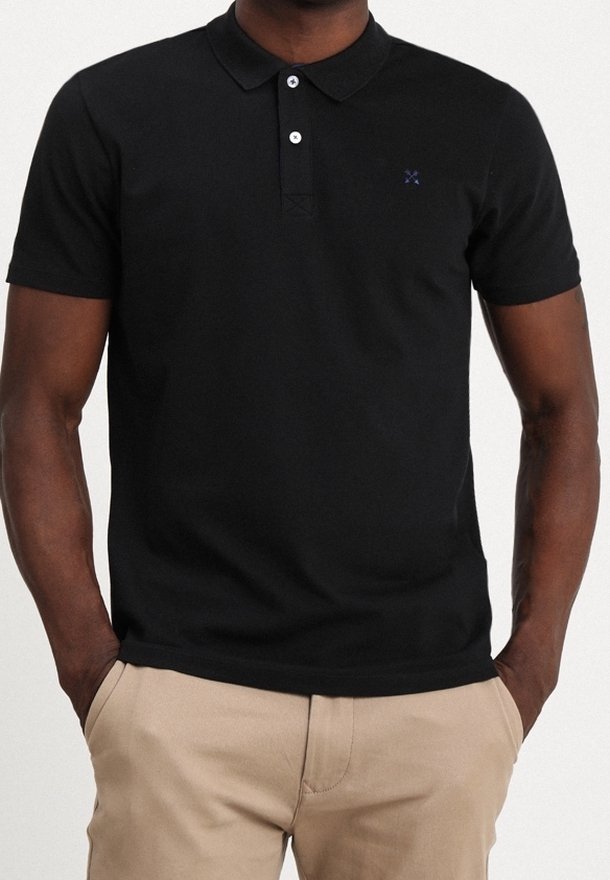 Polo noir en coton avec manches courtes, col et patte de boutonnage à trois boutons. Présente un petit logo bleu sur la poitrine gauche.