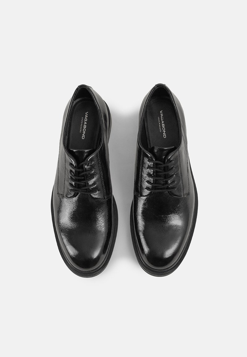 Zapatos de cuero negro con un acabado pulido, diseño de cordones y punta redonda, que cuentan con un tacón ligero y una suela de goma resistente.