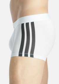 Weiße Boxershorts aus Baumwolle mit enger Passform, die drei vertikale schwarze Streifen an der Seite und einen weißen elastischen Bund haben.