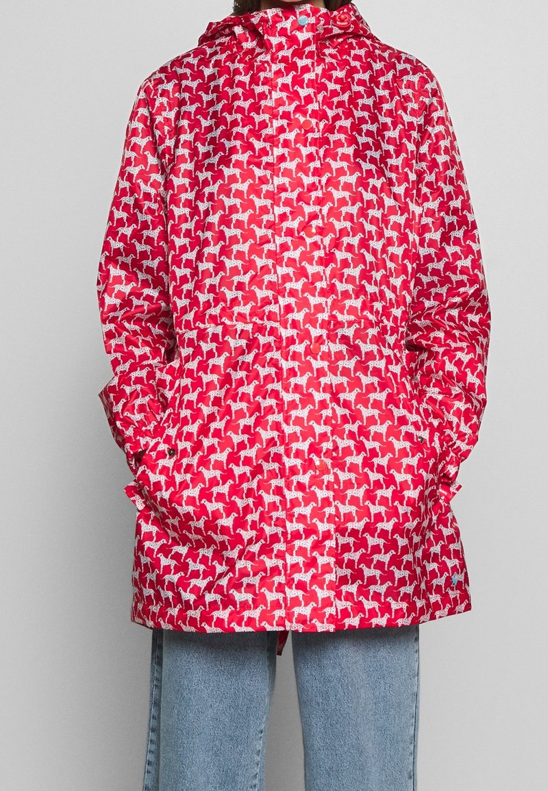 Czerwona wodoodporna kurtka z białym wzorem psów, z kapturem, długimi rękawami i kieszeniami bocznymi. Gładka, błyszcząca faktura.