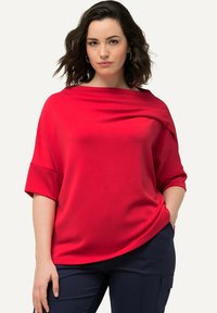 Haut surdimensionné rouge avec un col drapé et des manches courtes, fabriqué en tissu lisse. Présente une coupe décontractée pour un confort optimal.