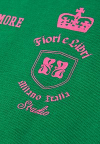 Zelená bavlněná látka s růžovým potiskem textu a znakem s nápisy "Fiori e Libri", "Milano Italia" a "Studio".