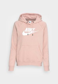 Light pink Nike hoodie with a kangaroo pocket, drawstring hood, and white logo on the front. Made from soft fabric with ribbed cuffs.