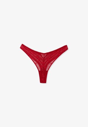 Tanga de encaje rojo con patrones florales, bordes festoneados y una cinturilla delgada. La tela ligera ofrece una apariencia delicada y transparente.