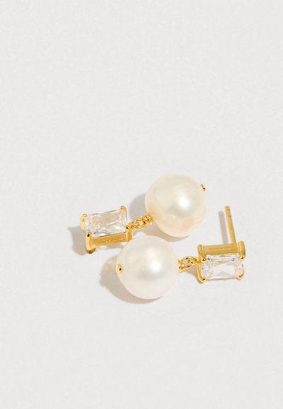 Brincos de ouro com grandes pérolas cremosas e cristais transparentes retangulares, detalhados com textura lisa e um design simples de pino.