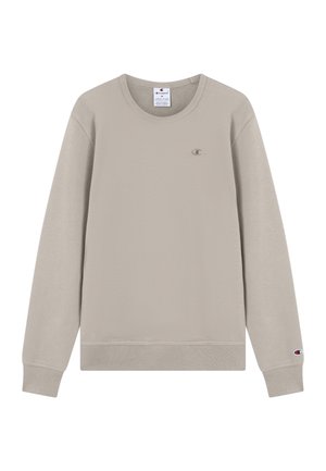 Sweat-shirt en polaire beige avec un col rond, des poignets et une taille côtelés. Présente un petit logo brodé sur la poitrine. Texture douce.