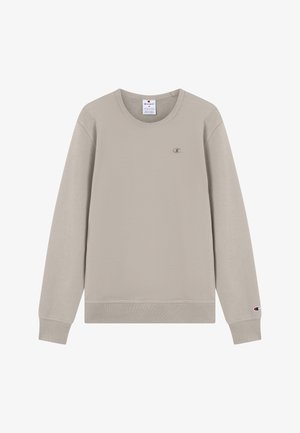 Sweat-shirt en polaire beige avec un col rond, des poignets et une taille côtelés. Présente un petit logo brodé sur la poitrine. Texture douce.