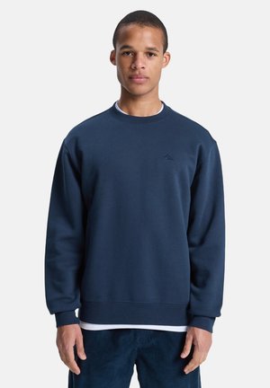 Navy blue sweatshirt with a crew neck, long sleeves, and ribbed cuffs. Features a subtle logo on the chest and a smooth fabric texture.