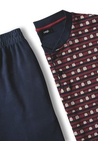 Pantaloni blu navy con vita elastica abbinati a una maglietta a strisce blu navy e rossa con un piccolo motivo di uccelli bianchi e bottoni sul petto.
