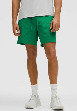 Gröna shorts i lätt material med elastisk midja och snördetalj. Matchas med vita skor och strumpor.